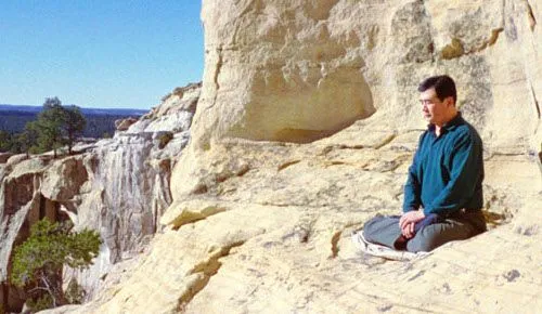 Г-н Ли Хонгджъ наблюдава от планината. Г-н Ли Хонгджъ е седнал с кръстосани крака и наблюдава от планината.