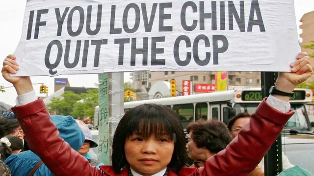 Жена държи банер "Ако обичаш Китай, се оттегли от ККП"