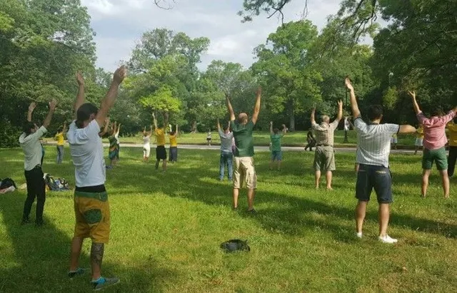 Група хора правят медитативно упражнение на Фалун Дафа на поляна. Група хора правят медитативно упражнение на Фалун Дафа на поляна.