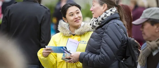 Жена раздава информационни листовки за Фалун Дафа.