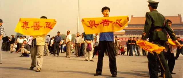 Последователи на Фалун Дафа държат банери в знак на протест на репресиите на площад в Китай.
