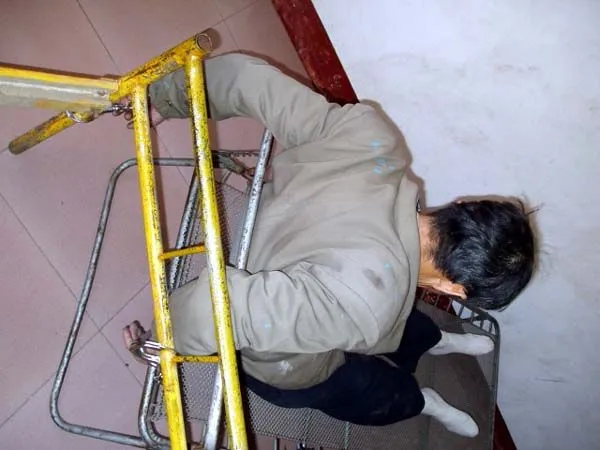 Мъж е завързан за рамка на легло и седи върху телена основа за матрак.