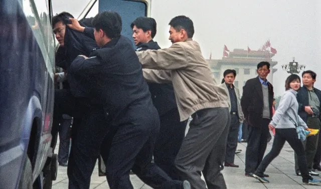 Последовател на Фалун Дафа е избутван в автомобил, за да бъде незаконно задържан.