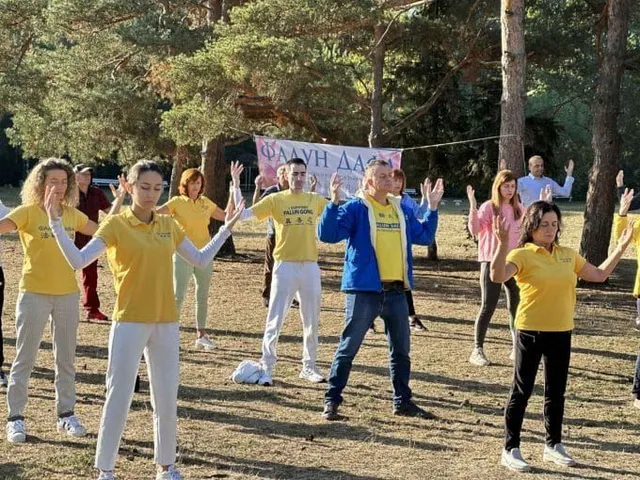 Група хора правят упражненията на Фалун Дафа в парк. Група хора правят второто упражнение на Фалун Дафа в парк.
