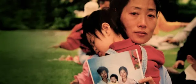 Скърбяща жена прегръща детето си.