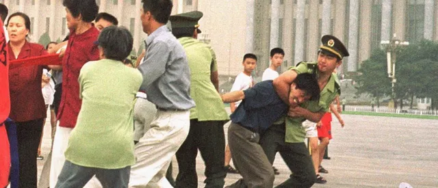 Полицаи се опитват да задържат практикуващи Фалун Дафа.